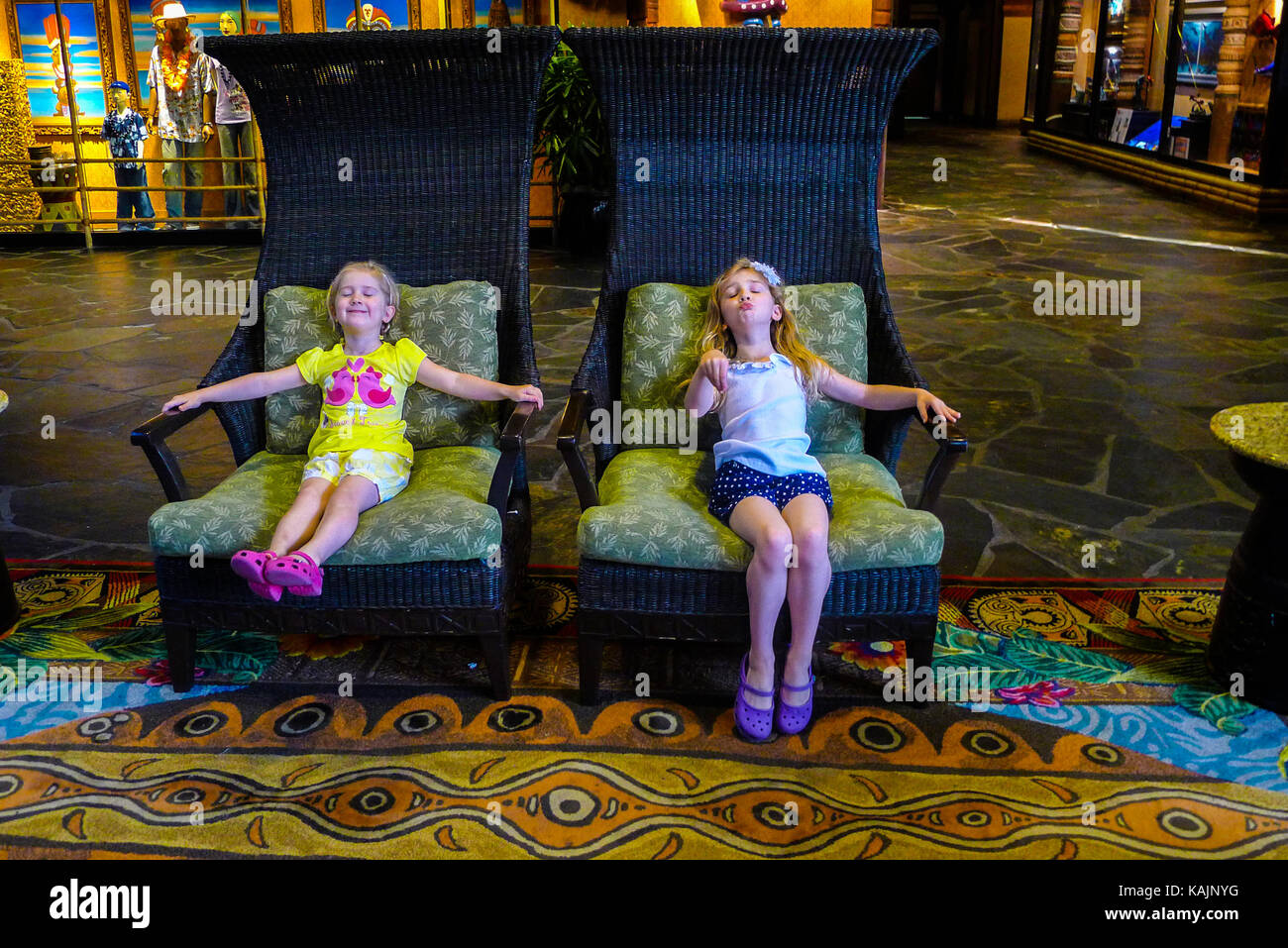 Children messing around in two giant chairs, disney world Stock Photo