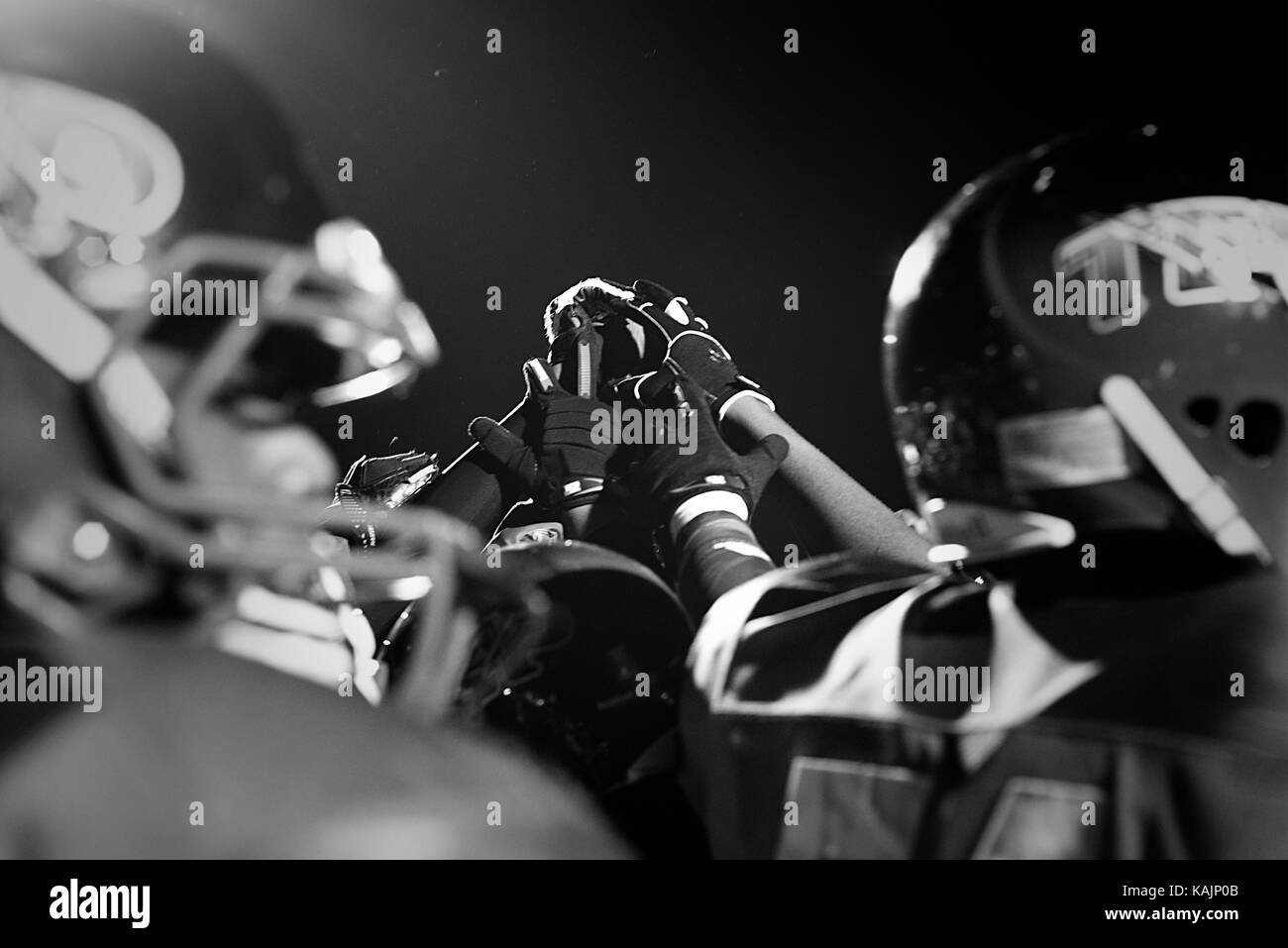 Philadelphia, PA, USA - November 15, 2013; Players of a high school football team hold hands high ahead of a championship game. Stock Photo
