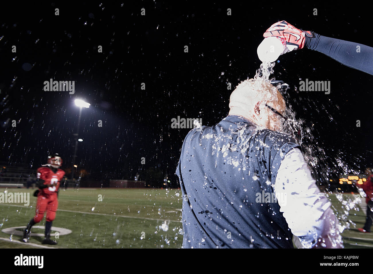 Philadelphia, PA, USA - November 15, 2013; An. High school football coach receives a celebratory shower after winning a city wide championships title, Stock Photo