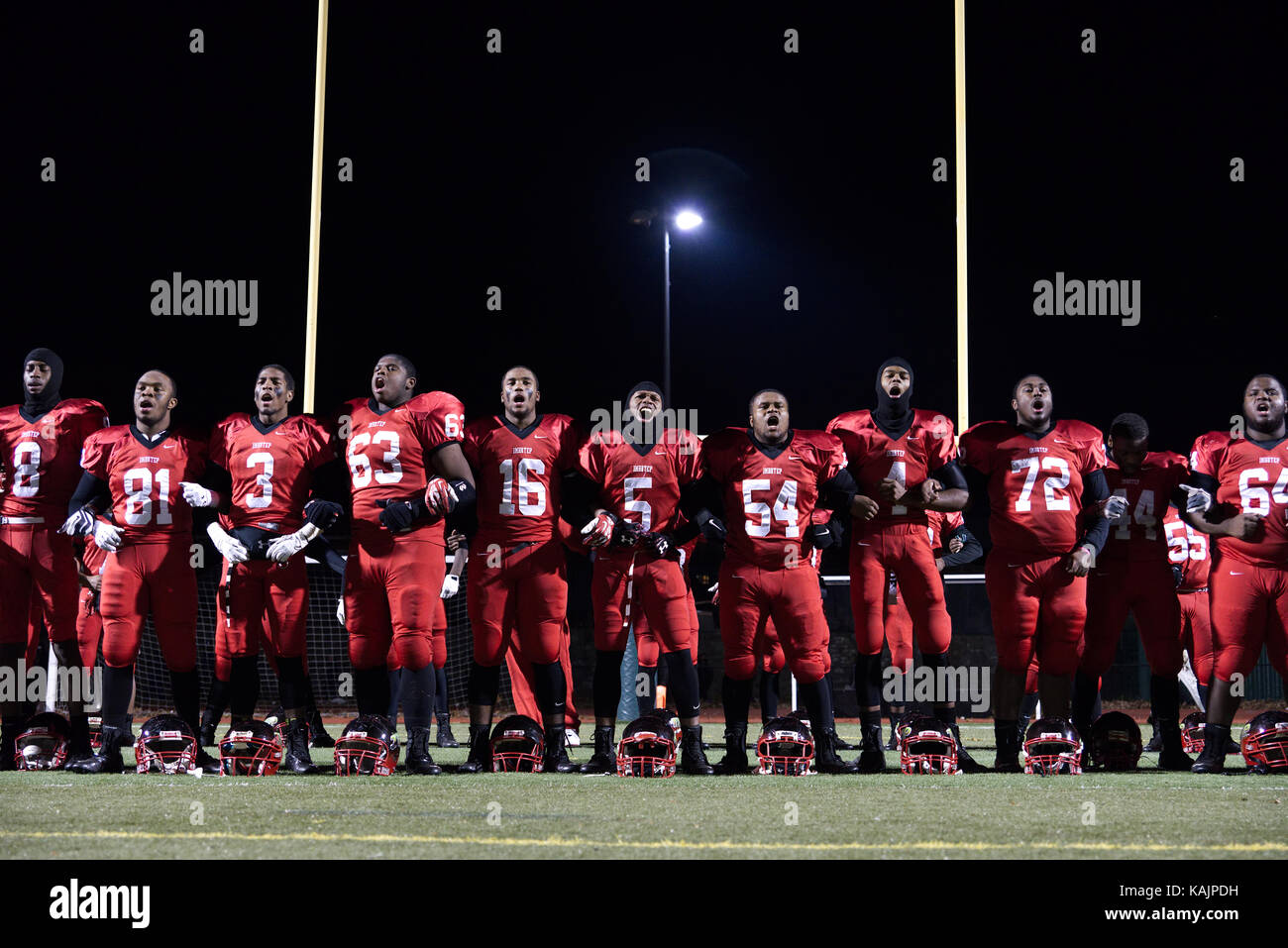 Philadelphia, PA, USA - November 15, 2013; High School football players lock arms after a game in celebration of winning the city wide championships t Stock Photo