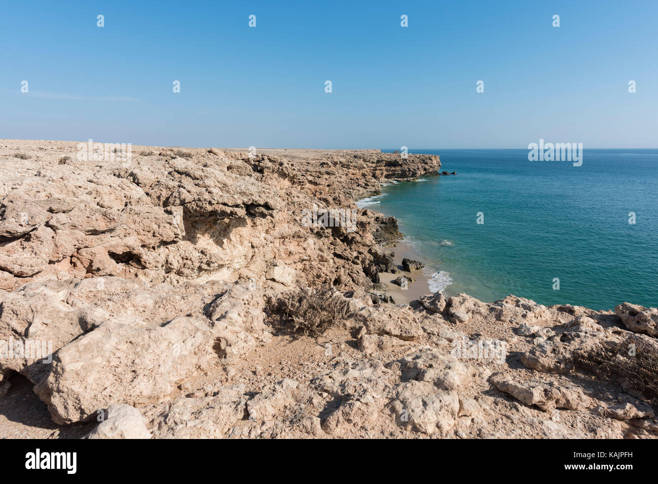 Top view from cliff of a wild beach at the coast of Ras Al Jinz with blue sky and copy space, Sultanate of Oman. Travel destination Stock Photo