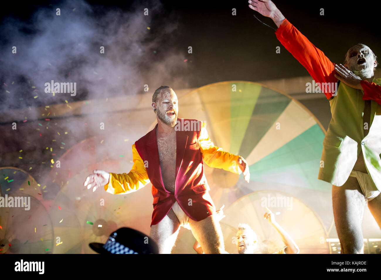 Male street festival performer dancing in front of a crowd of people with colorful background Stock Photo