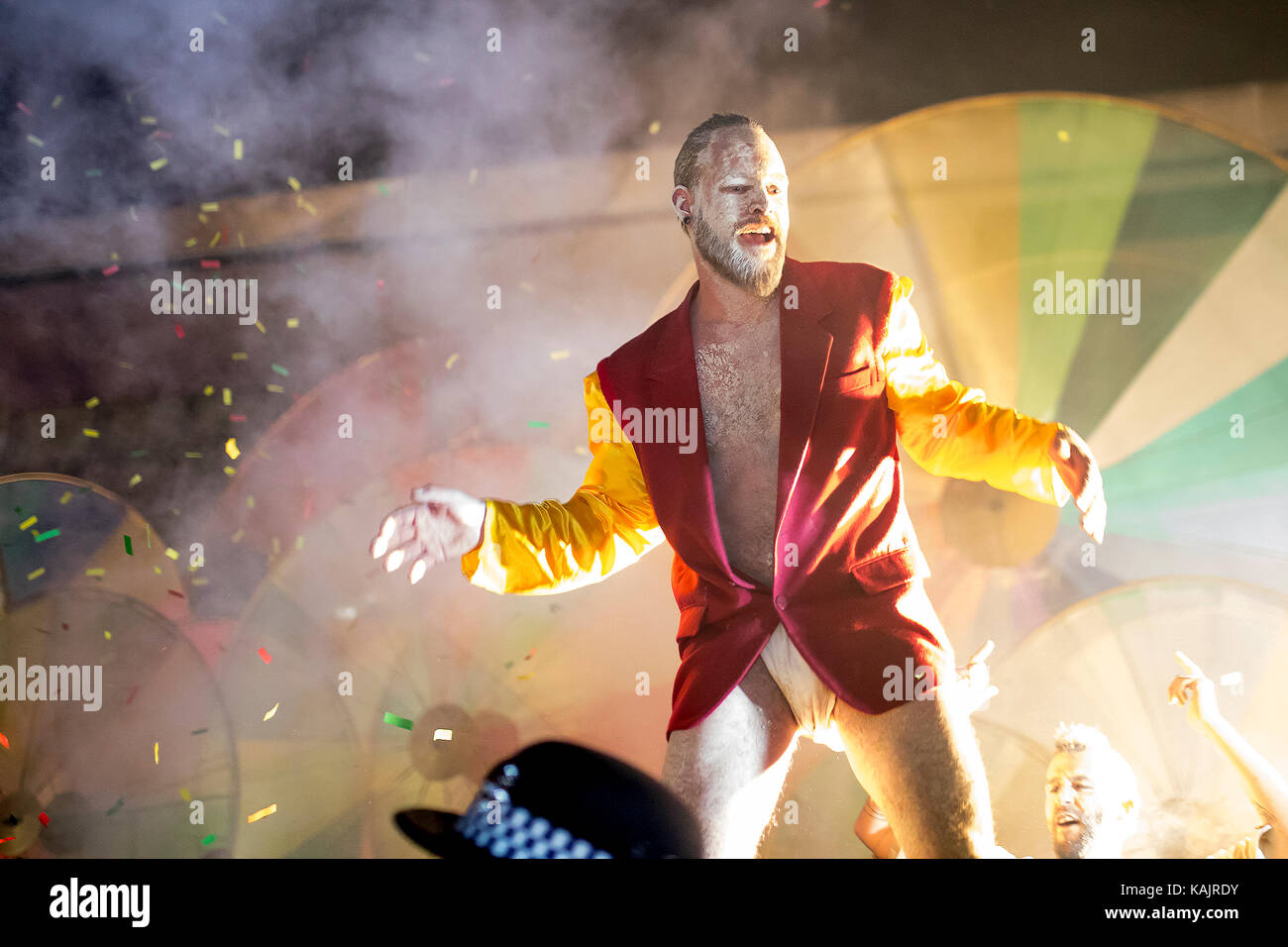 Male street festival performer dancing in front of a crowd of people with colorful background Stock Photo