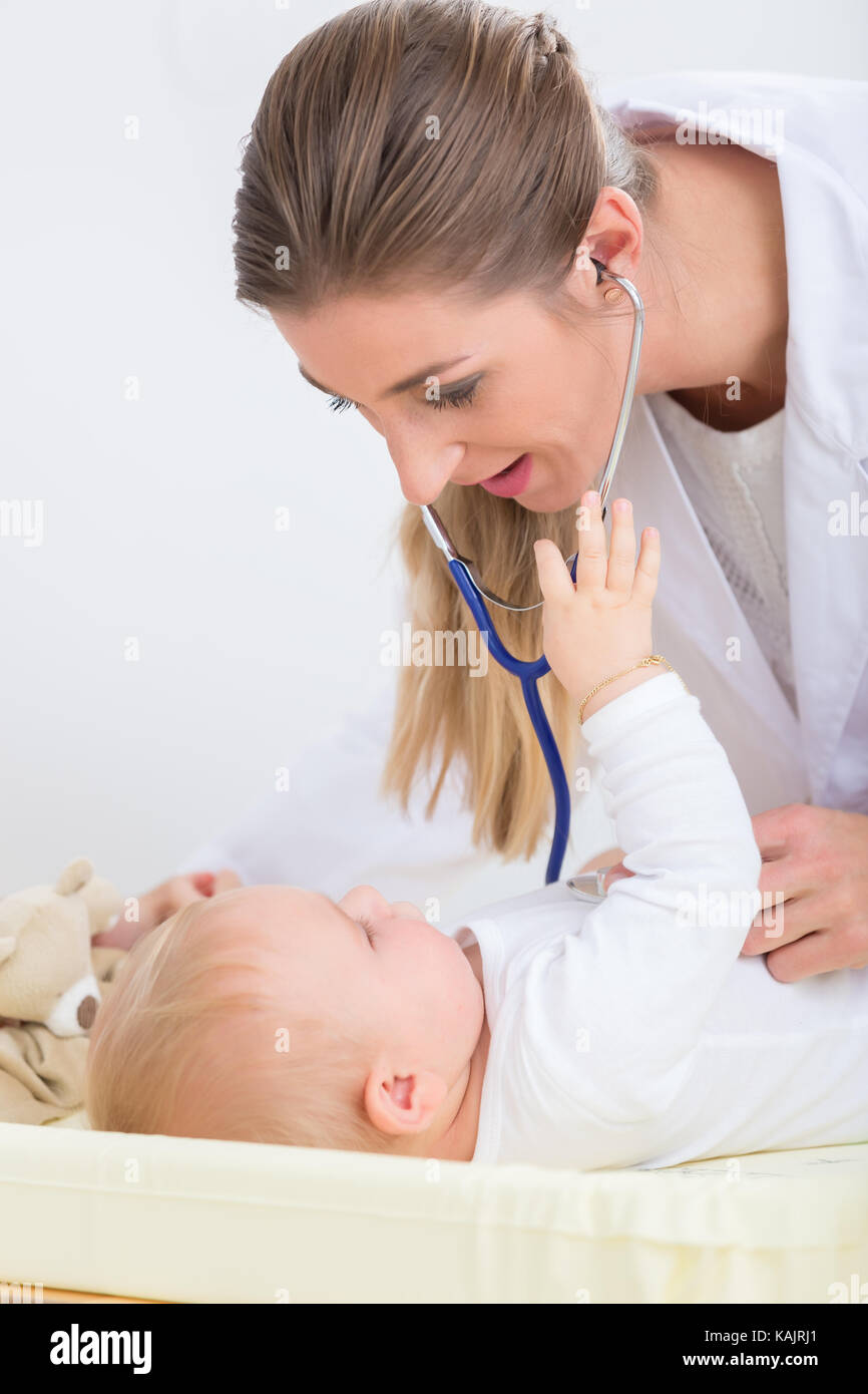 Dedicated female pediatrician using the stethoscope during the routine medical checkup of a