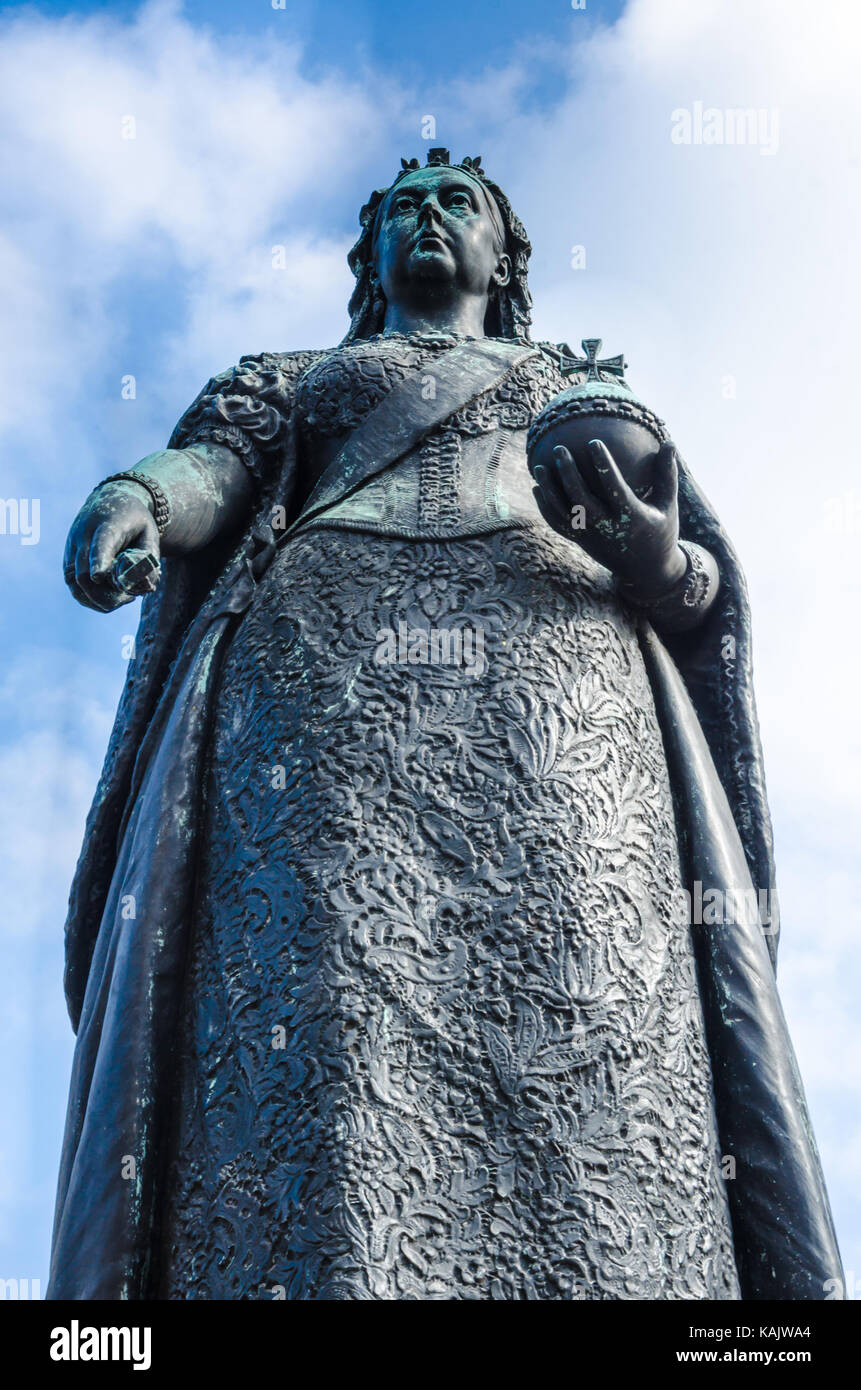 Looking up at a bronze statue of Queen Victoria which stands outside