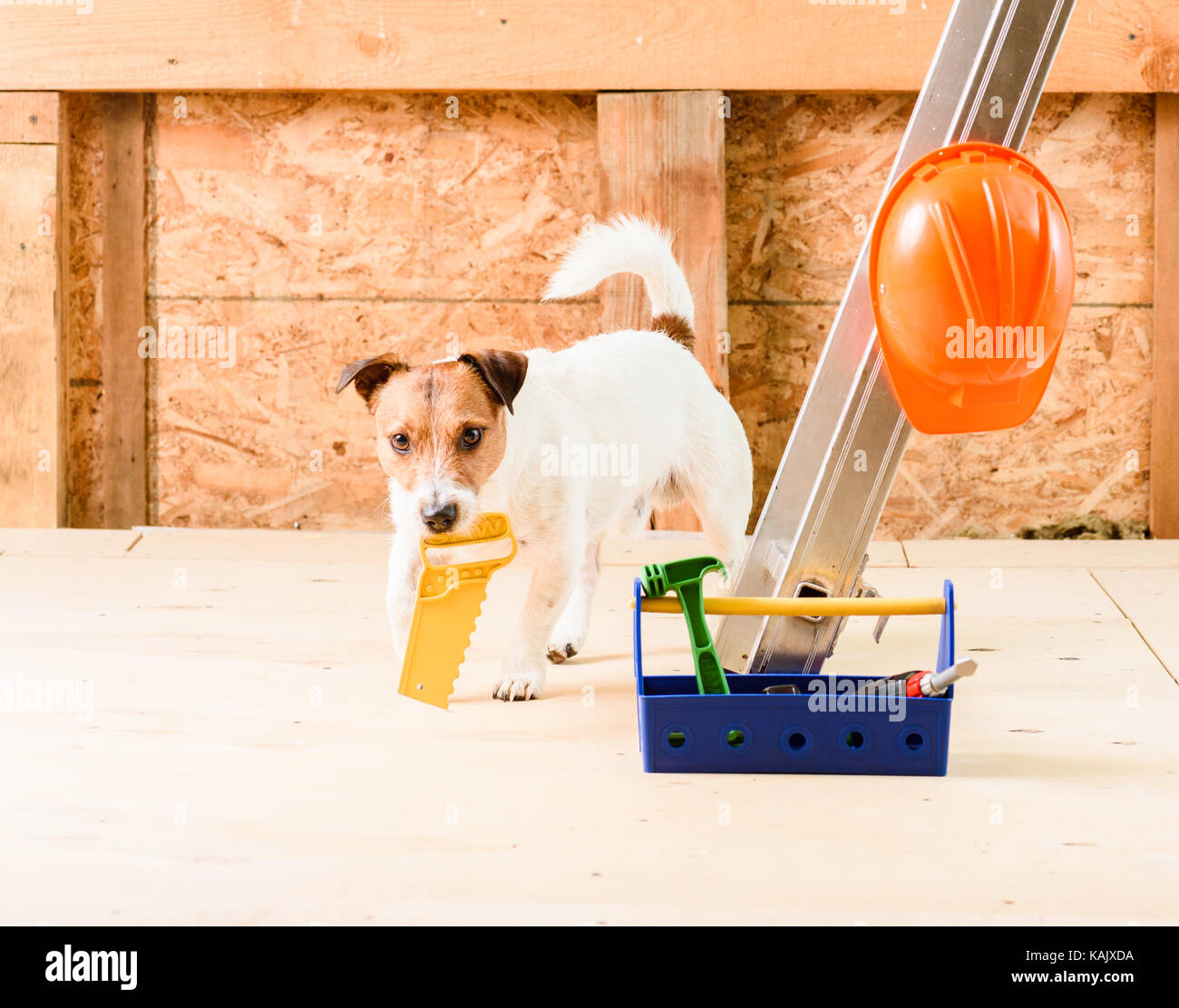 Funny carpenter worker with toy handsaw at construction site Stock Photo