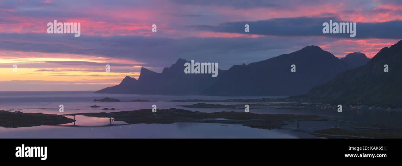 Panoramic view at Norwegian Lofoten coastline with rocks at dawn. Beautiful sunrise with red morning sky above Norway sea. Stock Photo