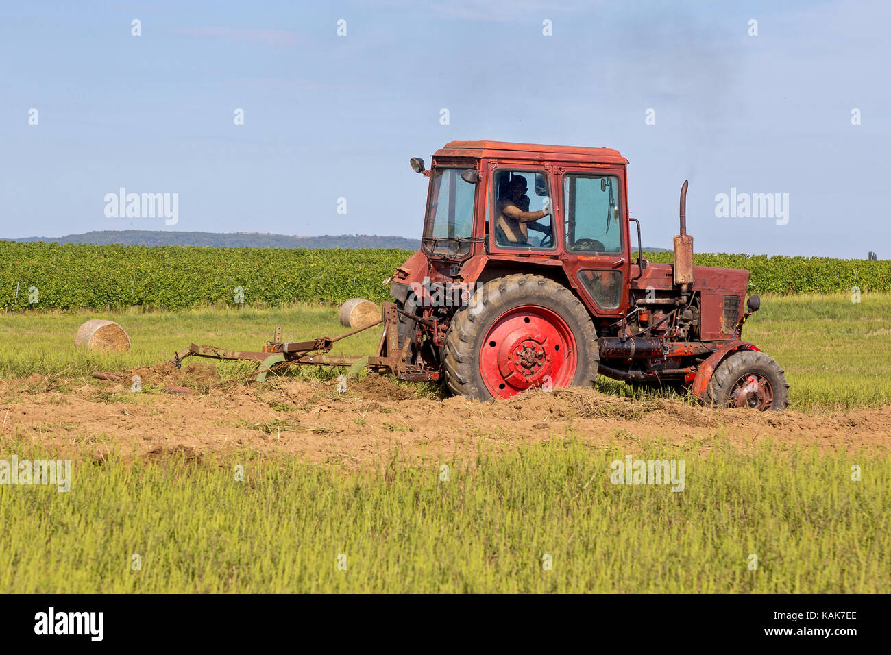 Old tractor working on the field Stock Photo Alamy