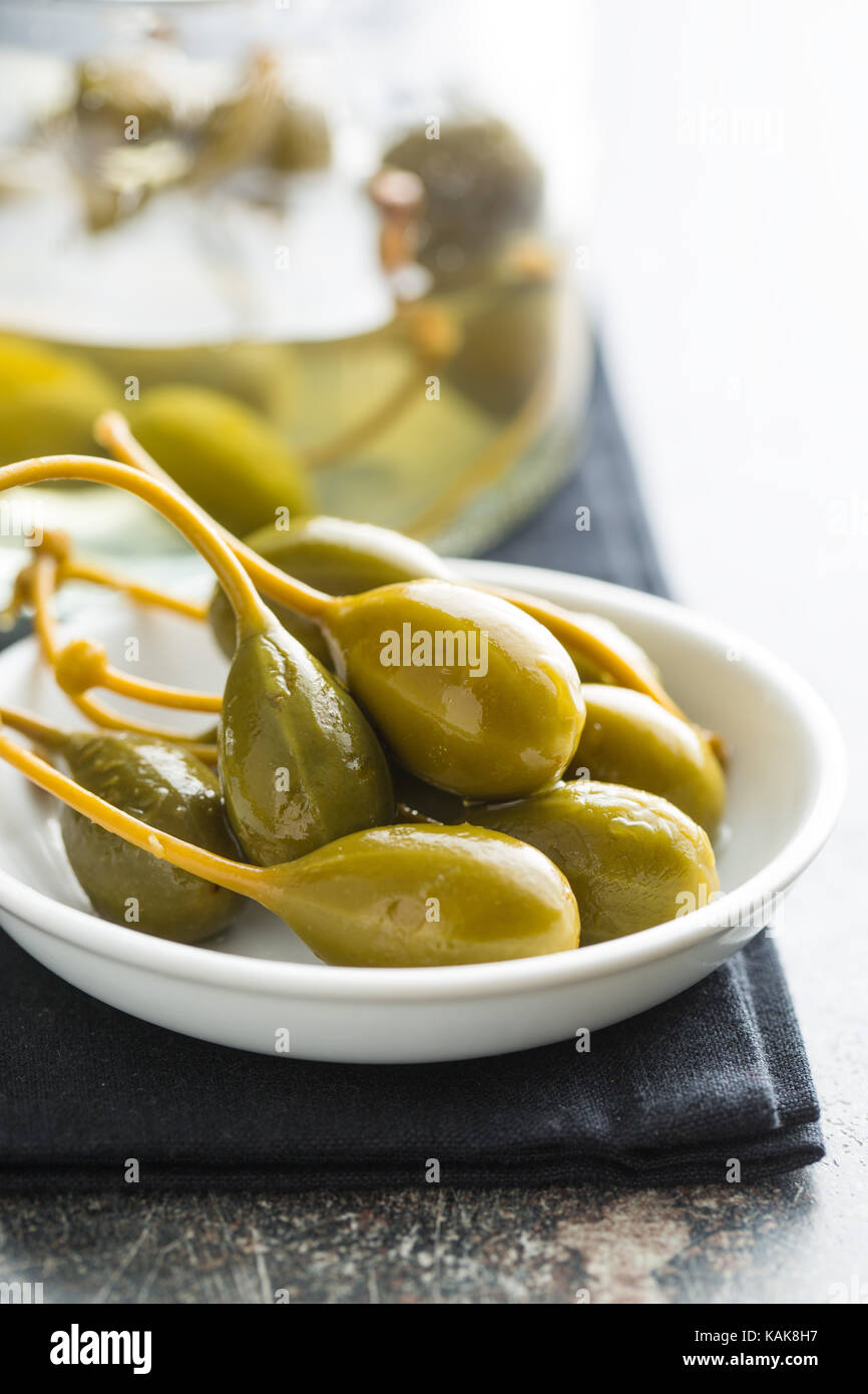 Pickled caper berries in bowl on kitchen table Stock Photo Alamy