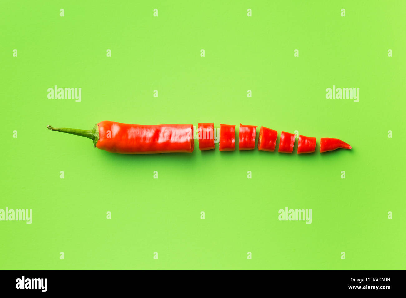 Red chili peppers on green background. Top view Stock Photo - Alamy