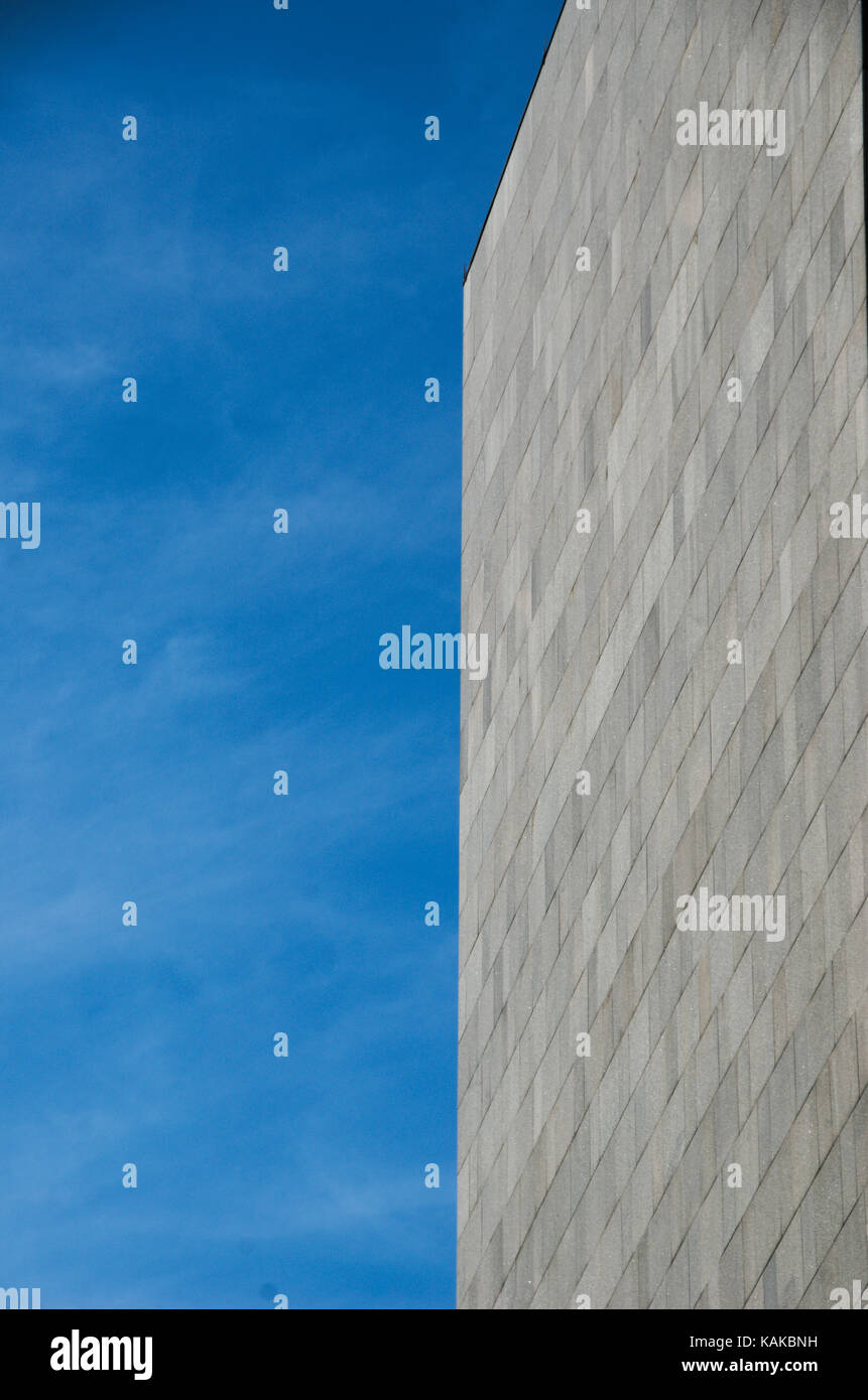 Sharp Vertical Edges of a Tall Grey Building on Blue Sky Background in Montreal, Canada. Stock Photo
