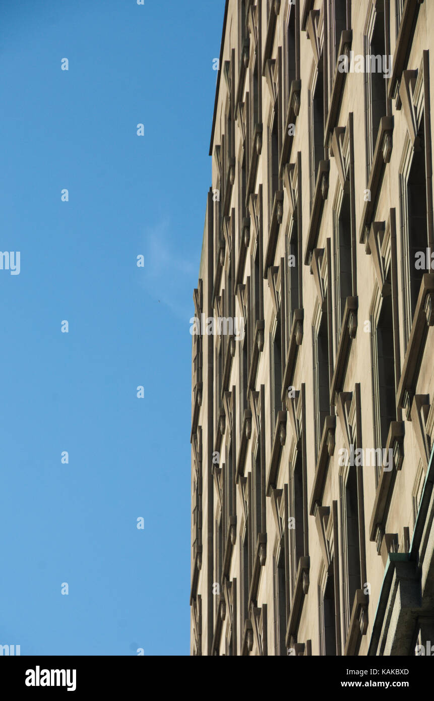 Sharp Vertical Edges of a Tall Building with nice windows effect on Blue Sky Background in Montreal, Canada. Stock Photo