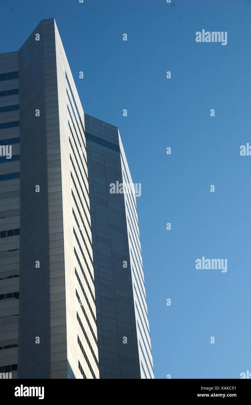 Sharp Vertical Edges of a Tall Grey Skyscraper Building on Blue Sky Background in Montreal, Canada. Stock Photo