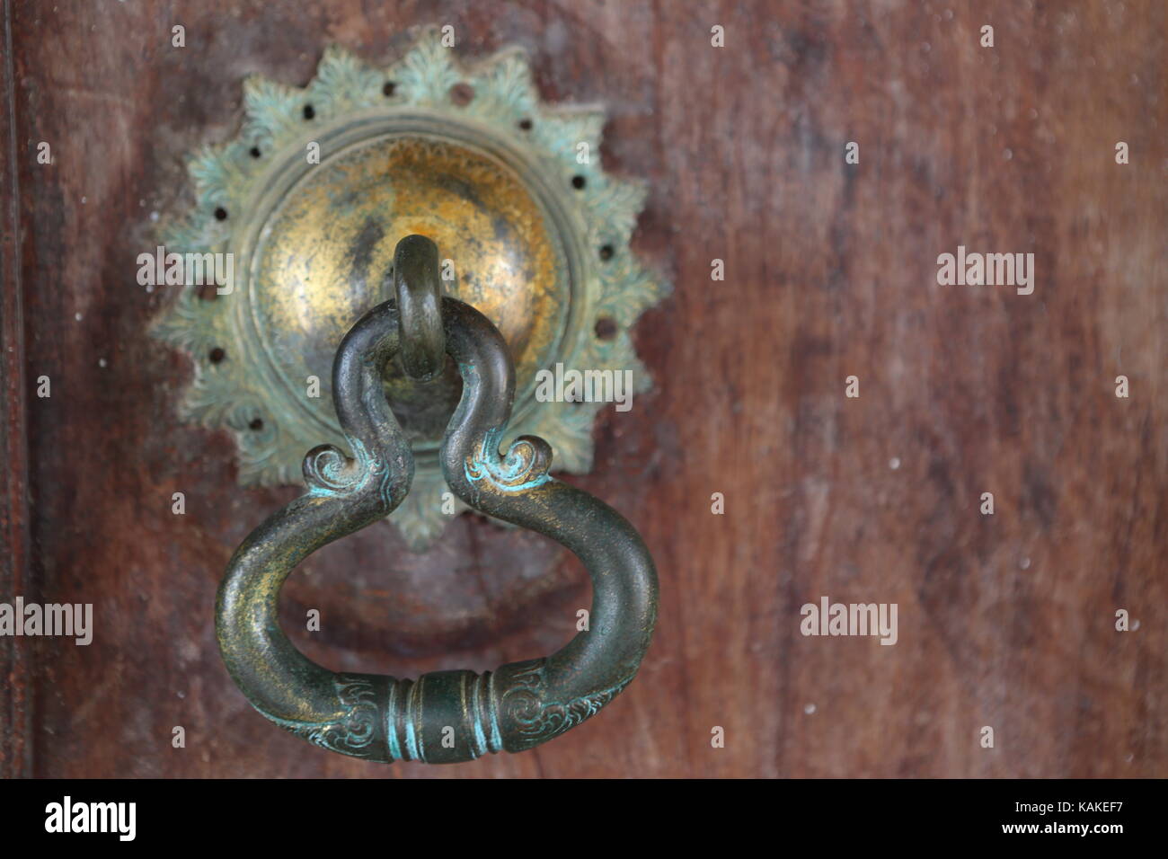 Door knocker made of metal on a wooden door ---Türklopfer aus Metall an einer Holztüre - Door opener Stock Photo