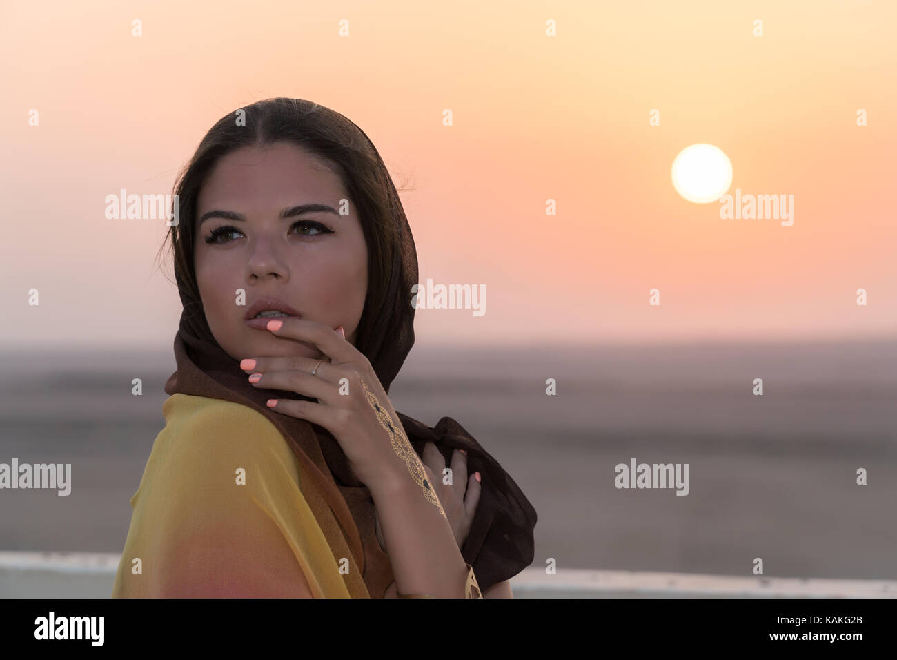 A beautiful girl dressed in Arabic style, standing on the roof at ...