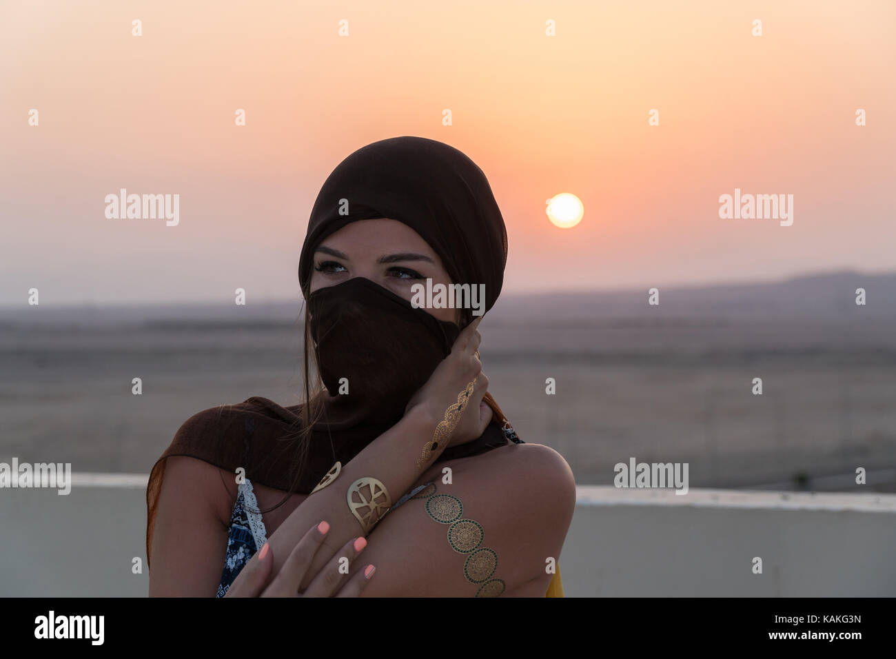 A beautiful girl dressed in Arabic style, standing on the roof at ...