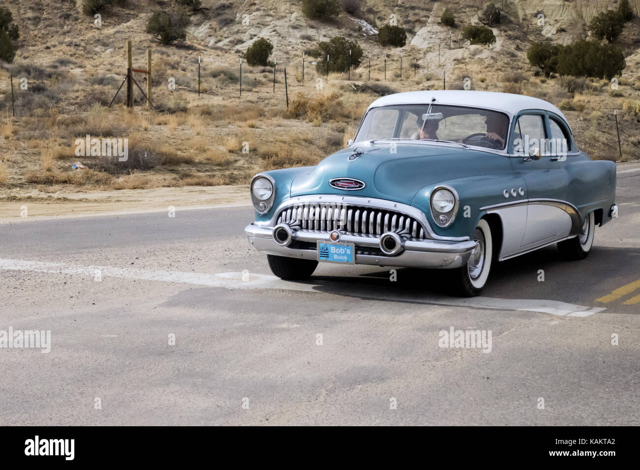 A Galena Blue two tone paint 1951 Buick special waiting at  intersection in the New Mexico desert. Stock Photo