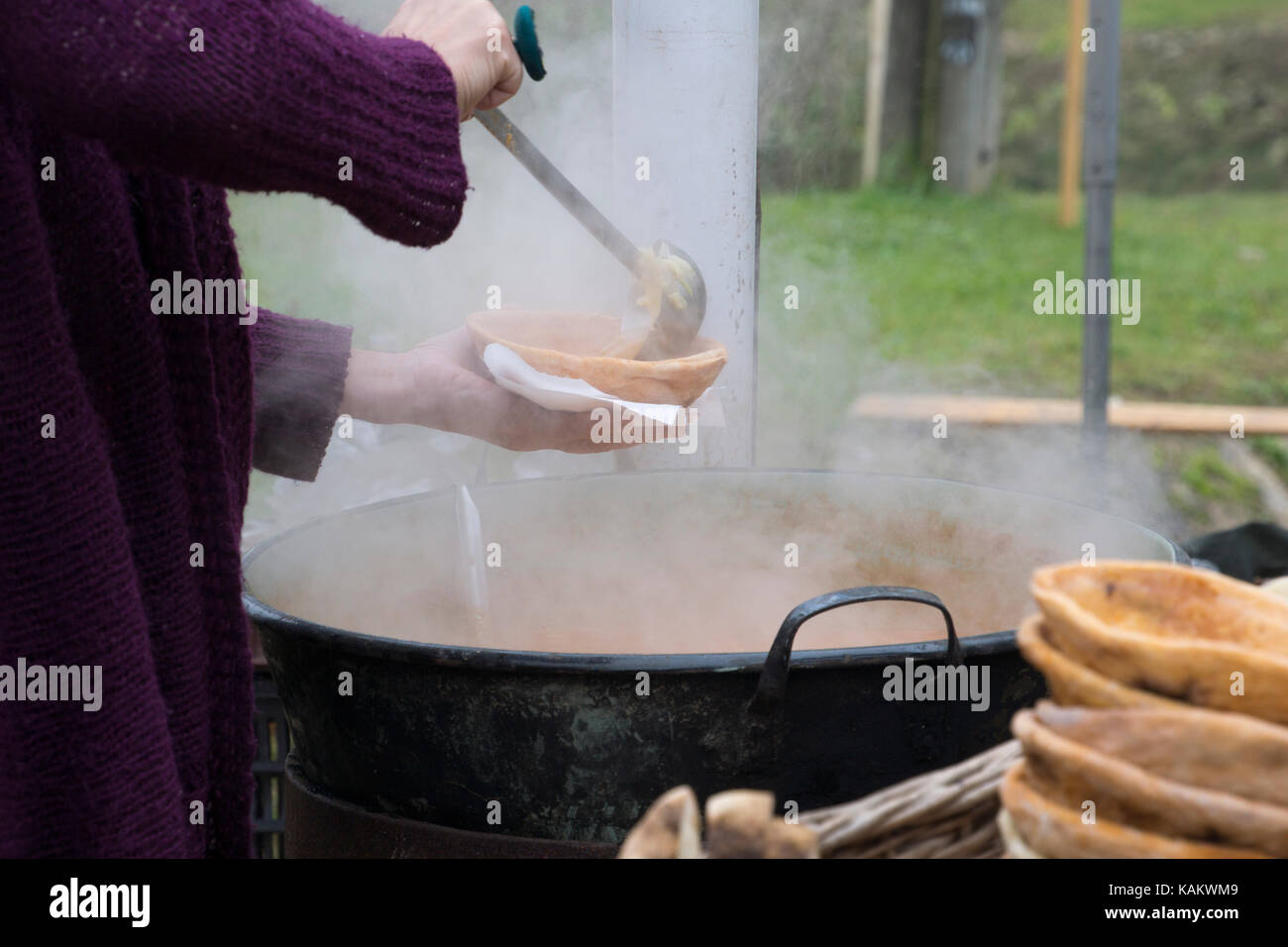 Woman pooring Hungarian goulash soup in a bread bowl Stock Photo Alamy