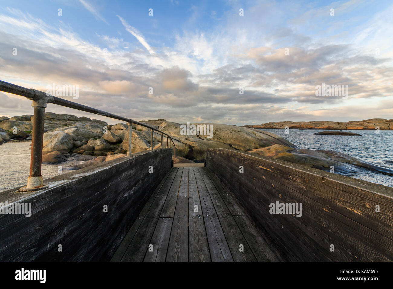wood bridge in sea landscape with clouds and sky above, Verdens Ende Vestfold, Norway Stock Photo