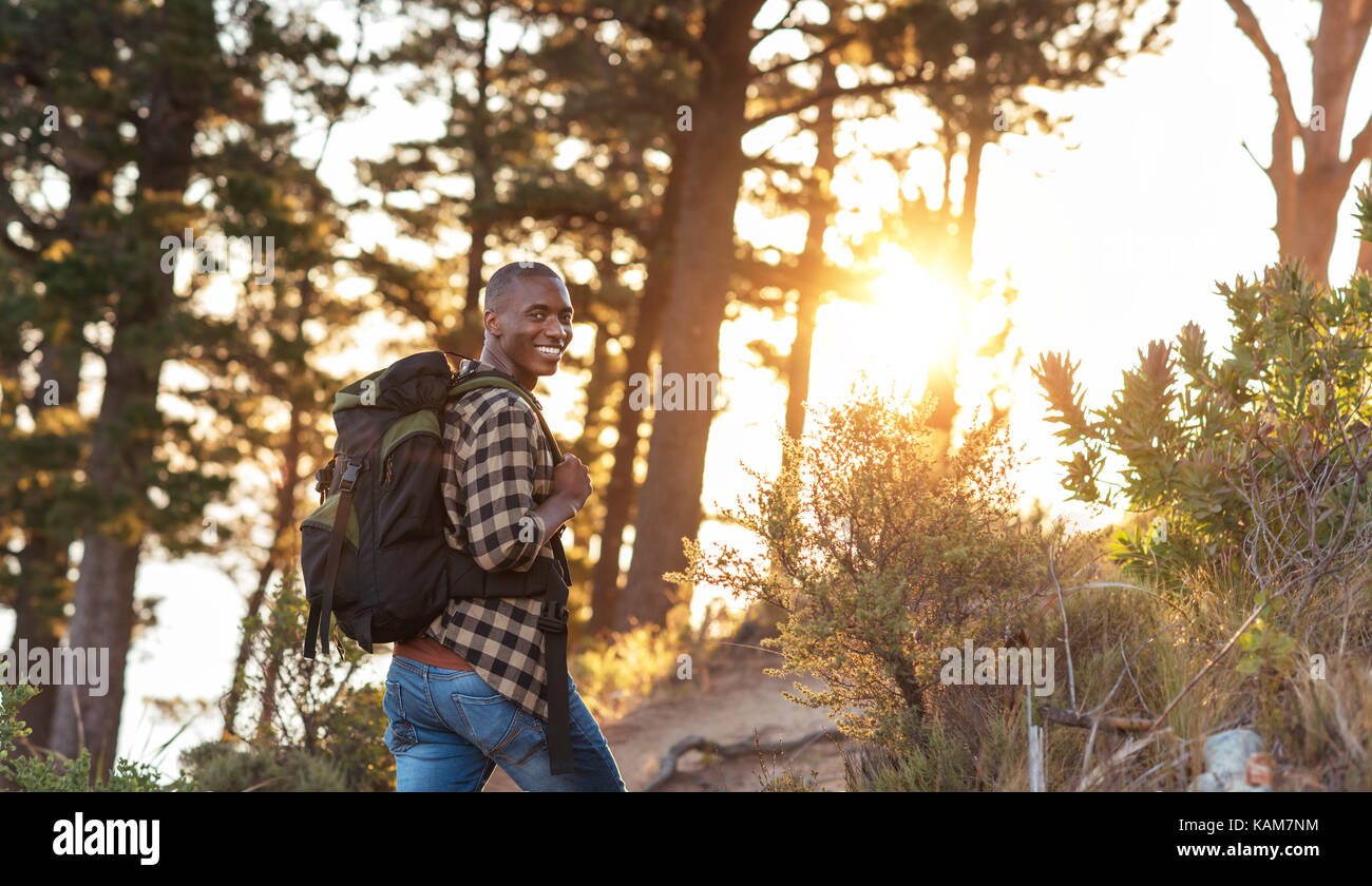 Smiling African man hiking in a forest in the afternoon Stock Photo - Alamy