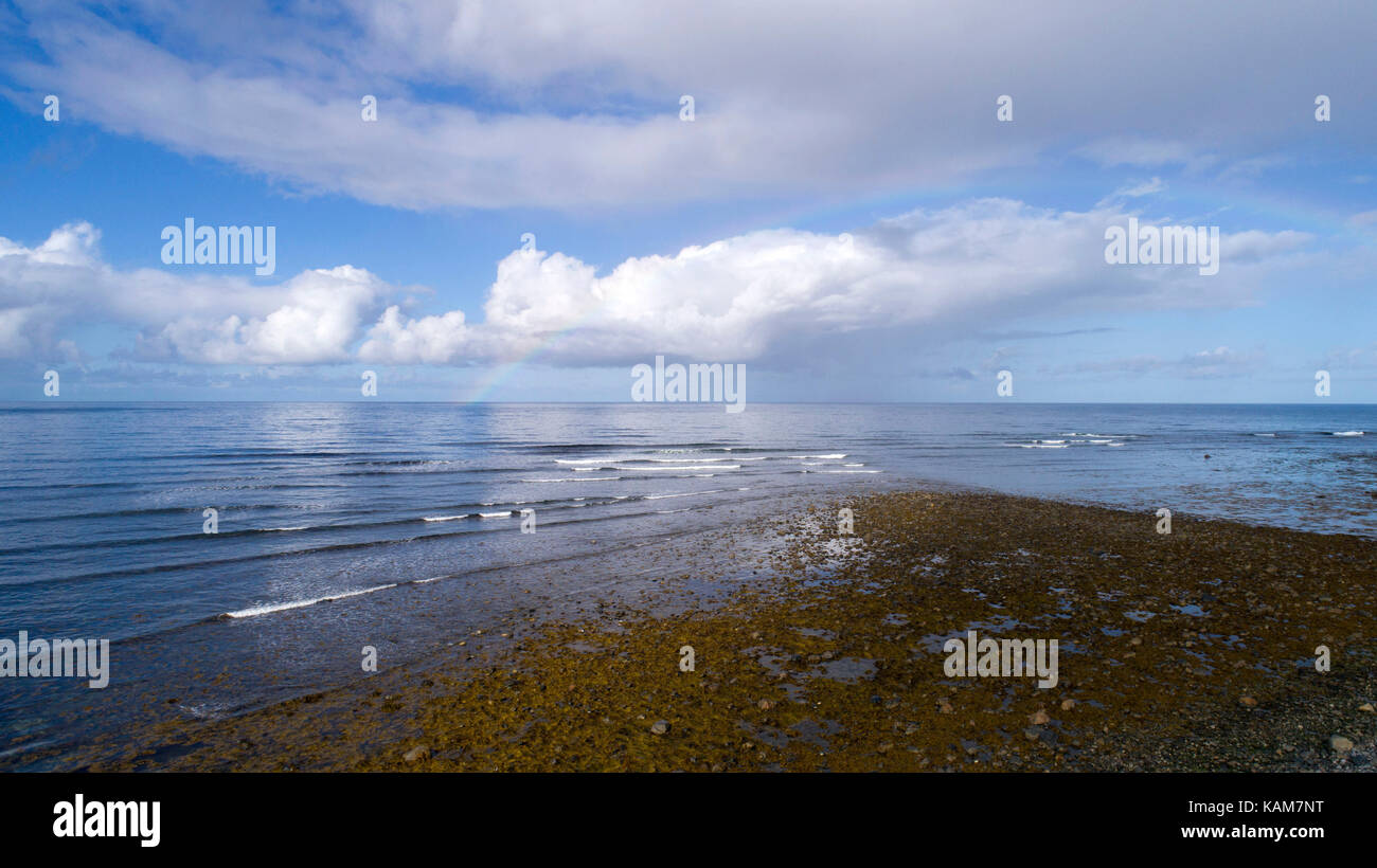 Rainbow over waves Stock Photo