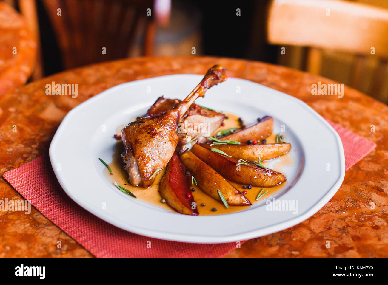 The side portrait of the grilled chicken feet and fried potatoes at the blurred background of the fashion restaurant. Stock Photo