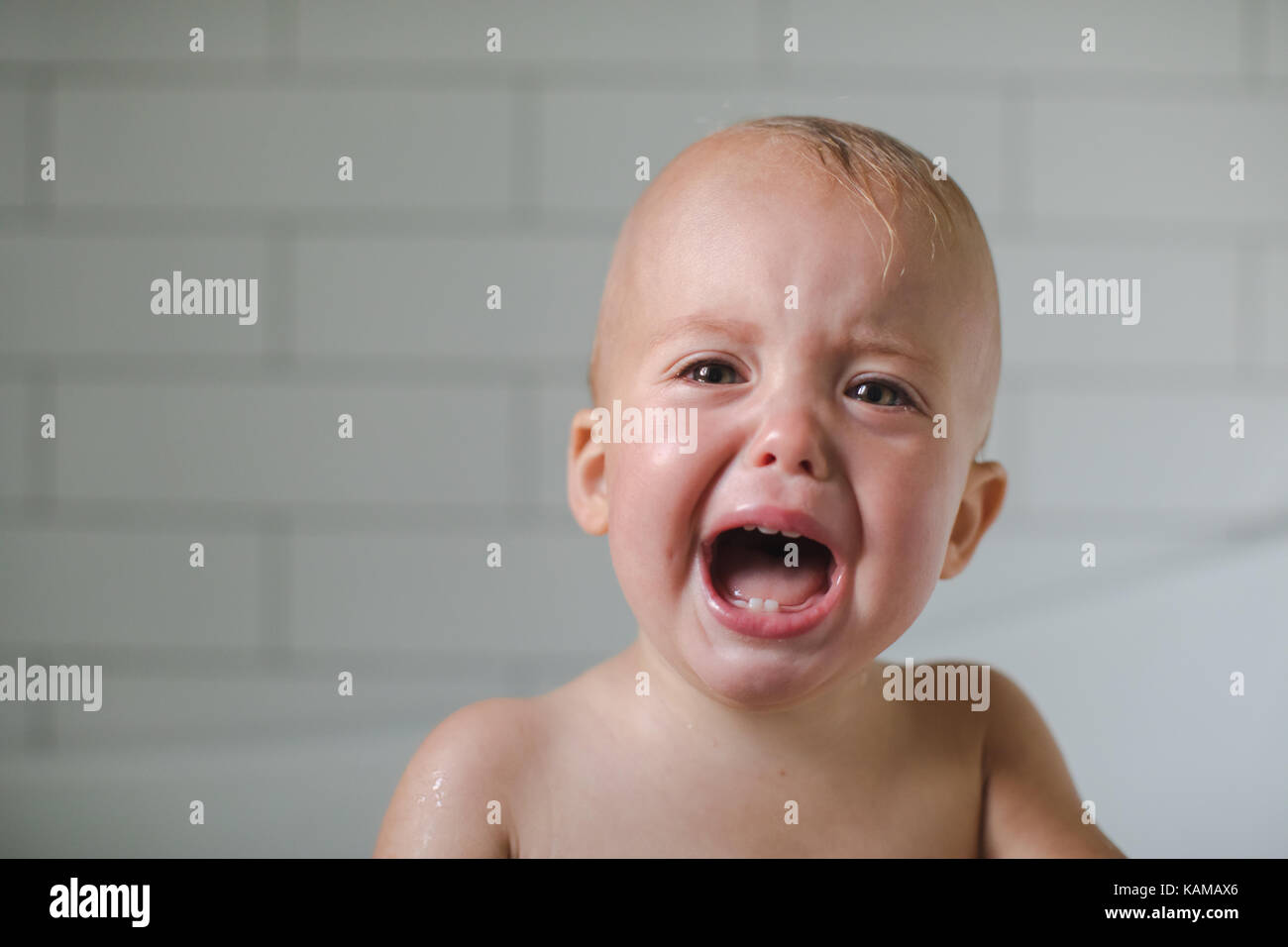 One-year-old baby cries close-up six teeth visible Stock Photo