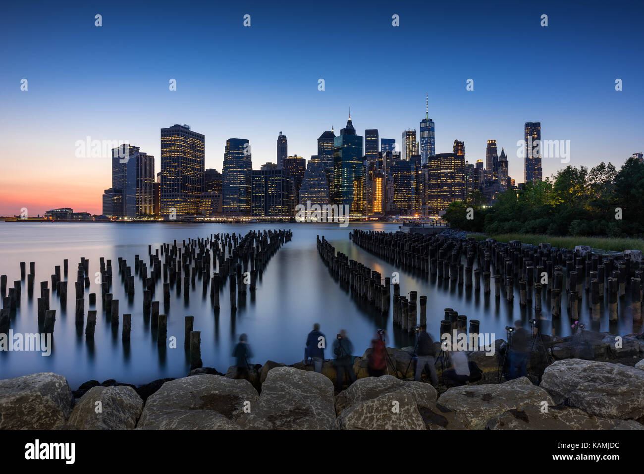 Skyscrapers of Lower Manhattan at sunset and wood pilings from Brooklyn Bridge Park. Manhattan, New York City Stock Photo