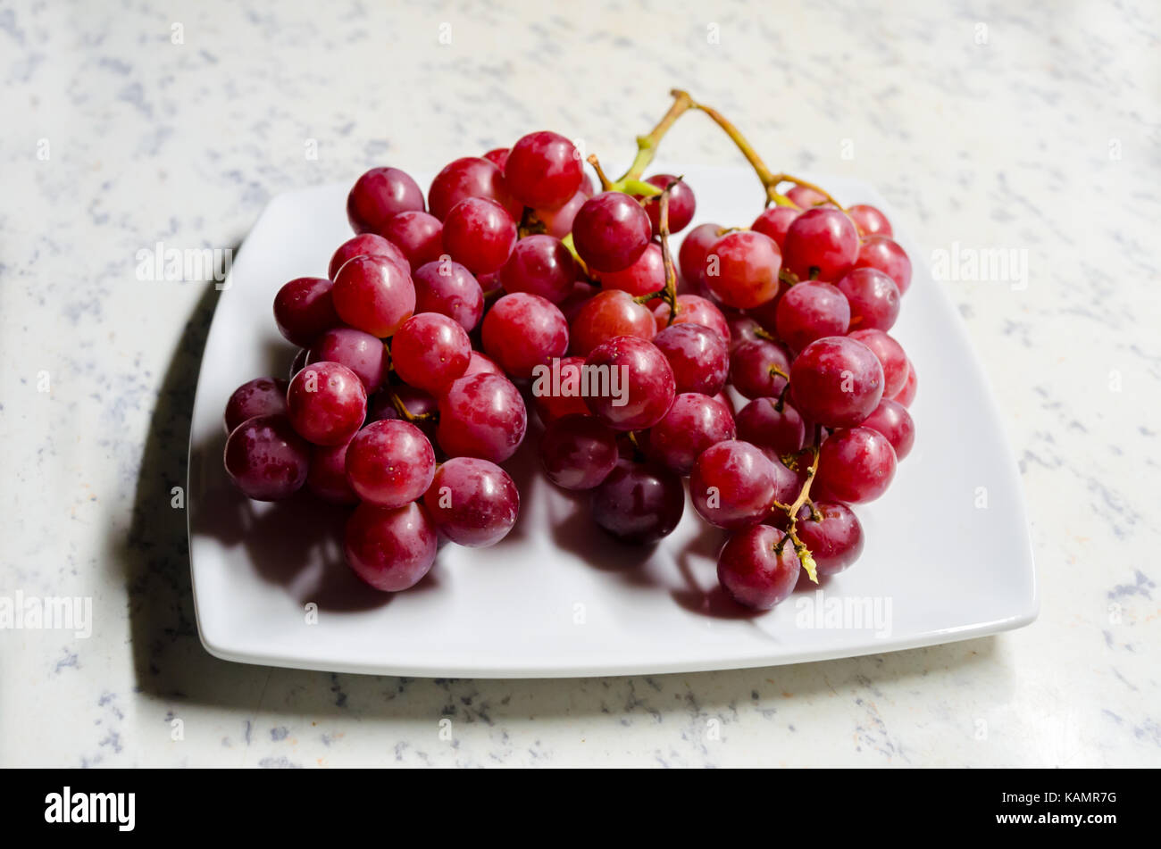 A Studio Photograph of a Bunch of 'Flame' Variety (Vitis Vinifera) Grapes on a Serving Plate Stock Photo