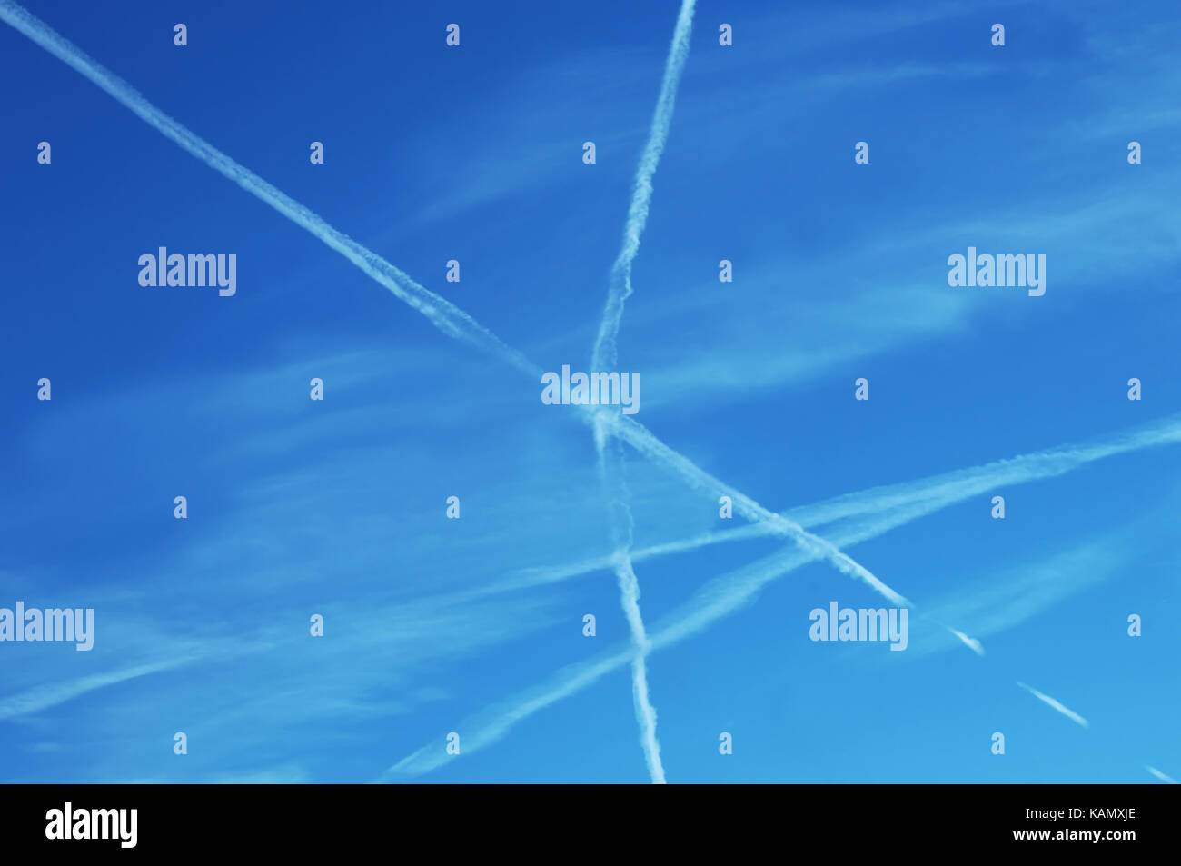 Jet flight patterns form an X in the sky.  Geometric math principle is illustrated by the crossing jet stream, intersecting lines. Stock Photo