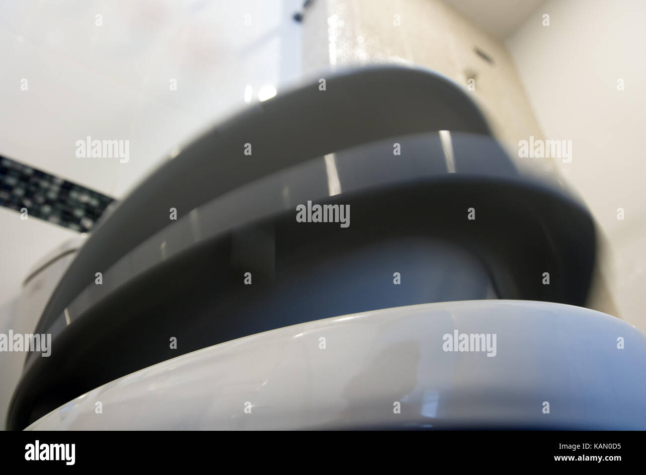 The toilet seat with lid moving down. The toilet bowl cover fall down. Cap of toilet bowl