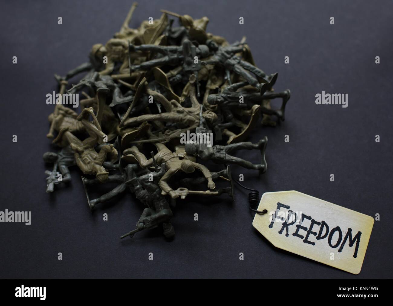 A pile of plastic toy soldiers with a tag that reads 'freedom'. Stock Photo