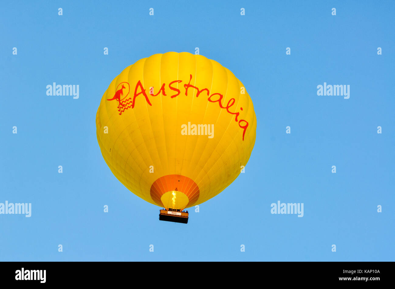 Yellow Hot Air Balloon flying in mid-air, Mareeba, Queensland, QLD, Australia Stock Photo