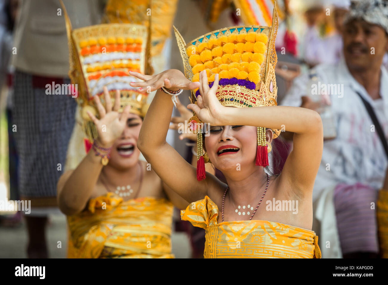 Two wailing women during a traditional Balinese cultural dance fall in to trance at this Bali dance ceremony on Kuningan day a religious Bali event Stock Photo