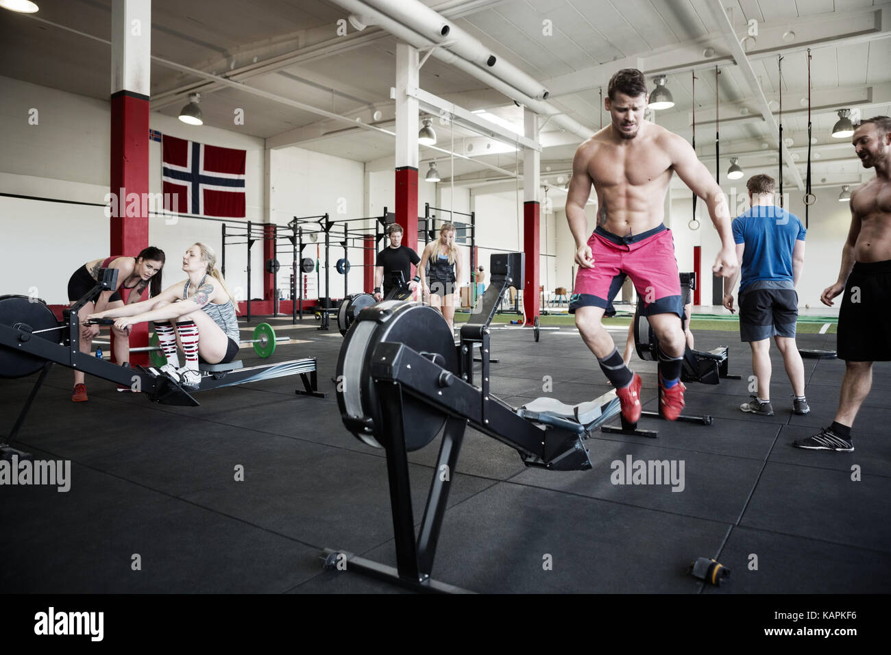Shirtless Man Jumping By Rowing Machine Stock Photo - Alamy