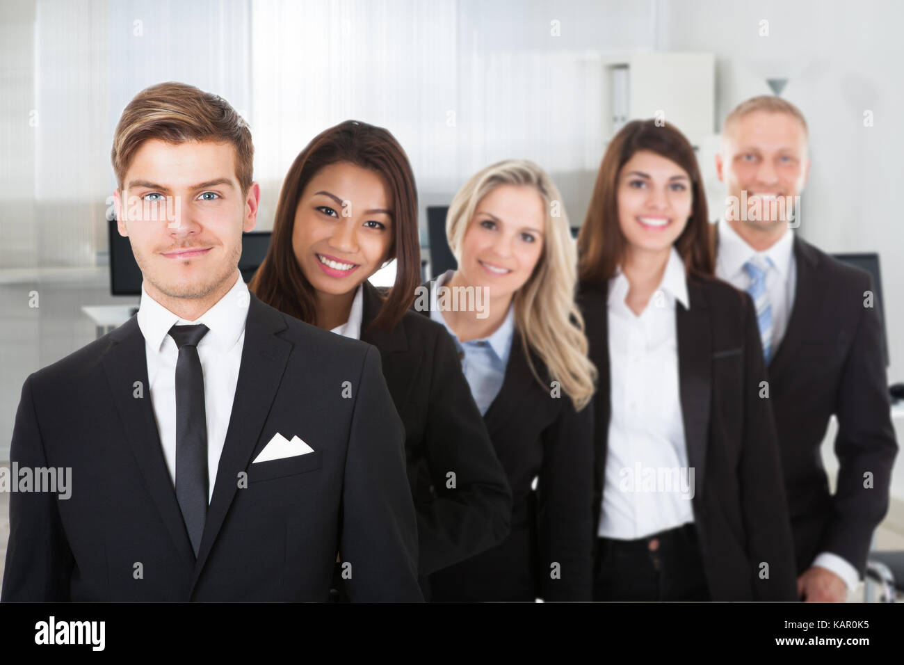Portrait of multiethnic male and female professionals standing in row at office Stock Photo