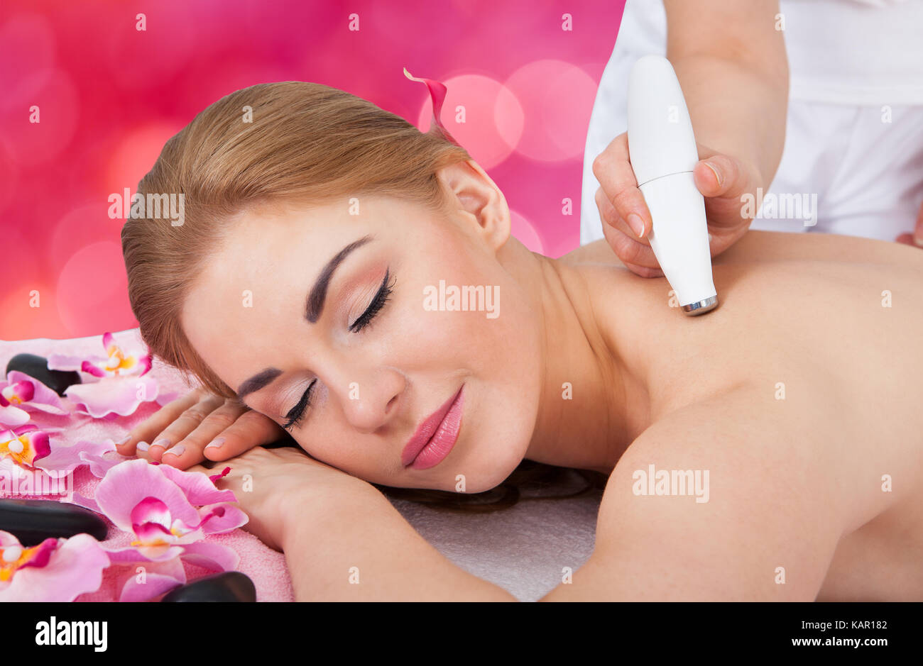 Relaxed young woman receiving microdermabrasion therapy at beauty spa Stock Photo