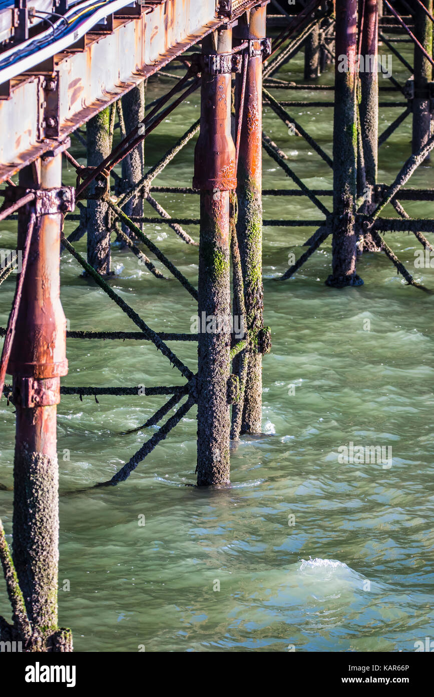 Iron pier legs of Southend Pier with red corrosion and barnacles. Thames Estuary Stock Photo