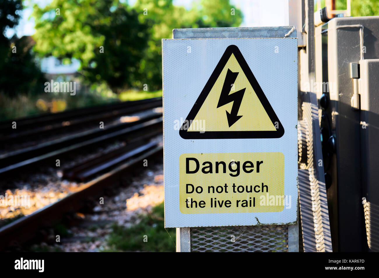 The triangular yellow sign of the danger of electric shock at a local rail station, UK Stock Photo