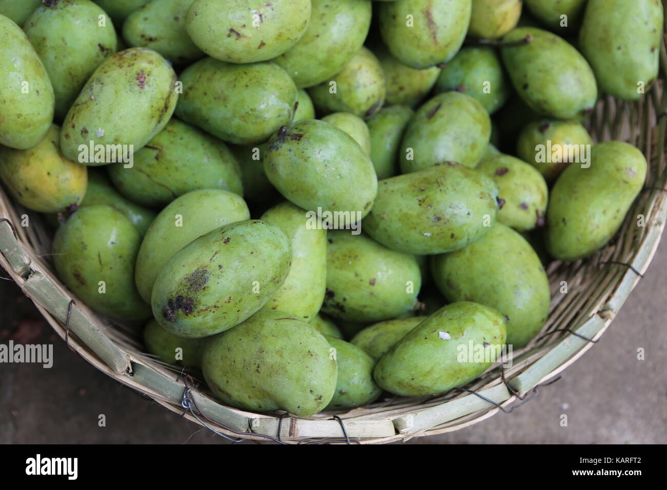 Green mangoes in a basket on an asian market --- Grüne Mangos in einem Korb auf einem asiatischen markt Stock Photo