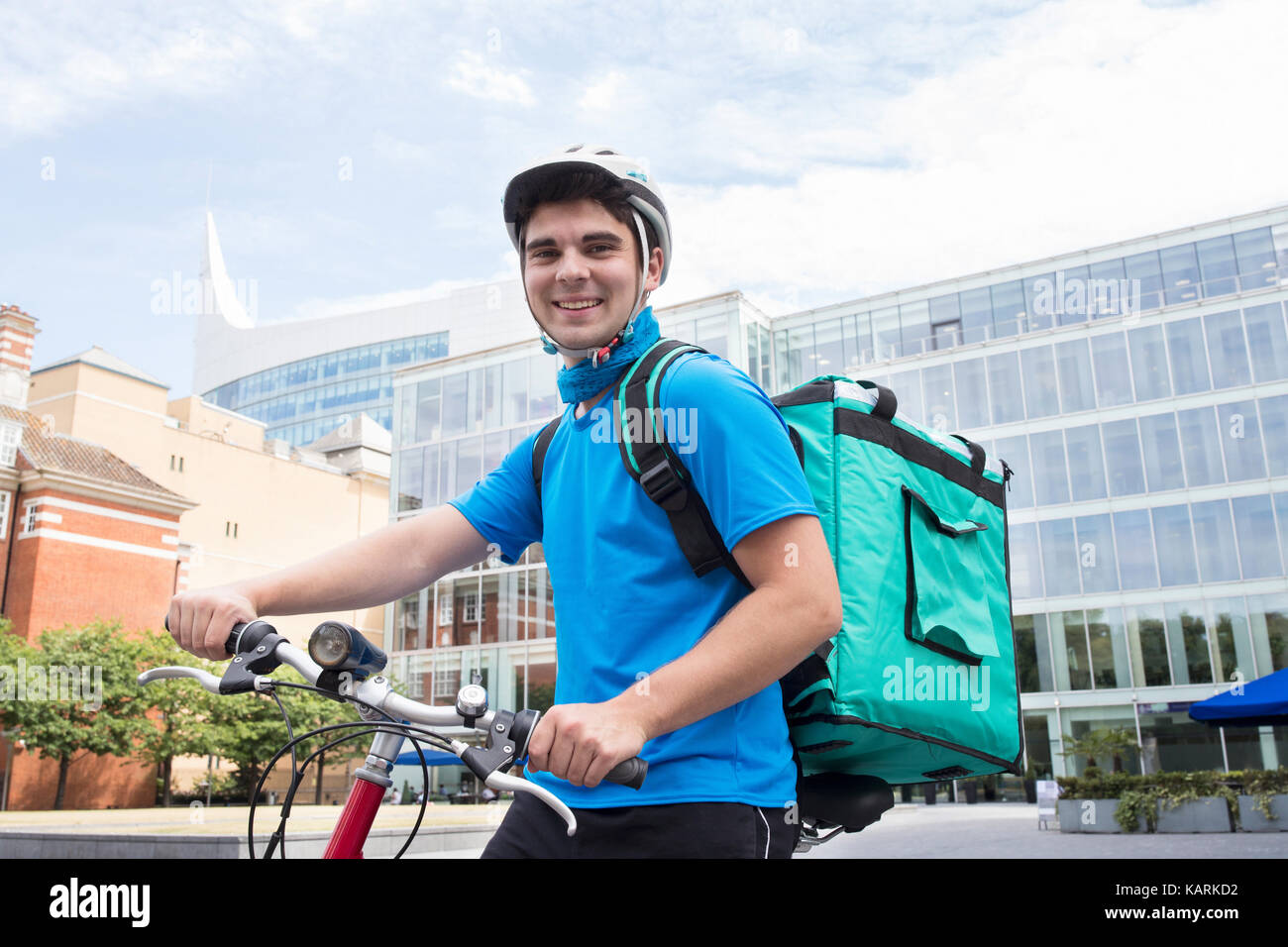 Portrait Of Courier On Bicycle Delivering Food In City Stock Photo