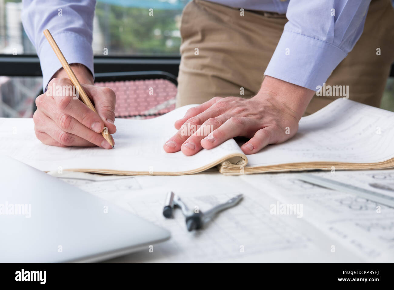 Plan Inspects architect working on construction plan at office. engineer inspect ...