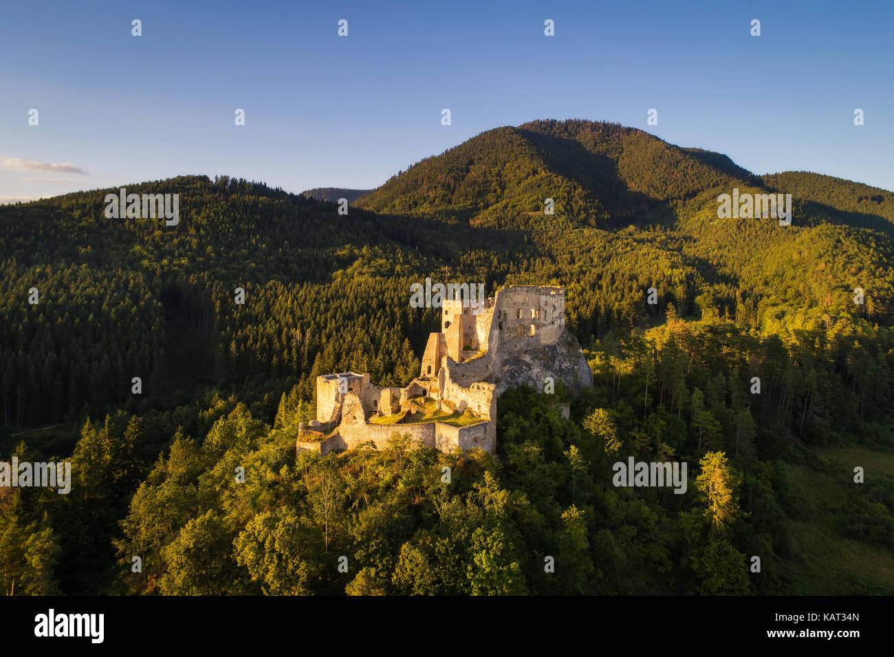 Abandoned ruins of a medieval castle in the golden evening light at sunset Stock Photo