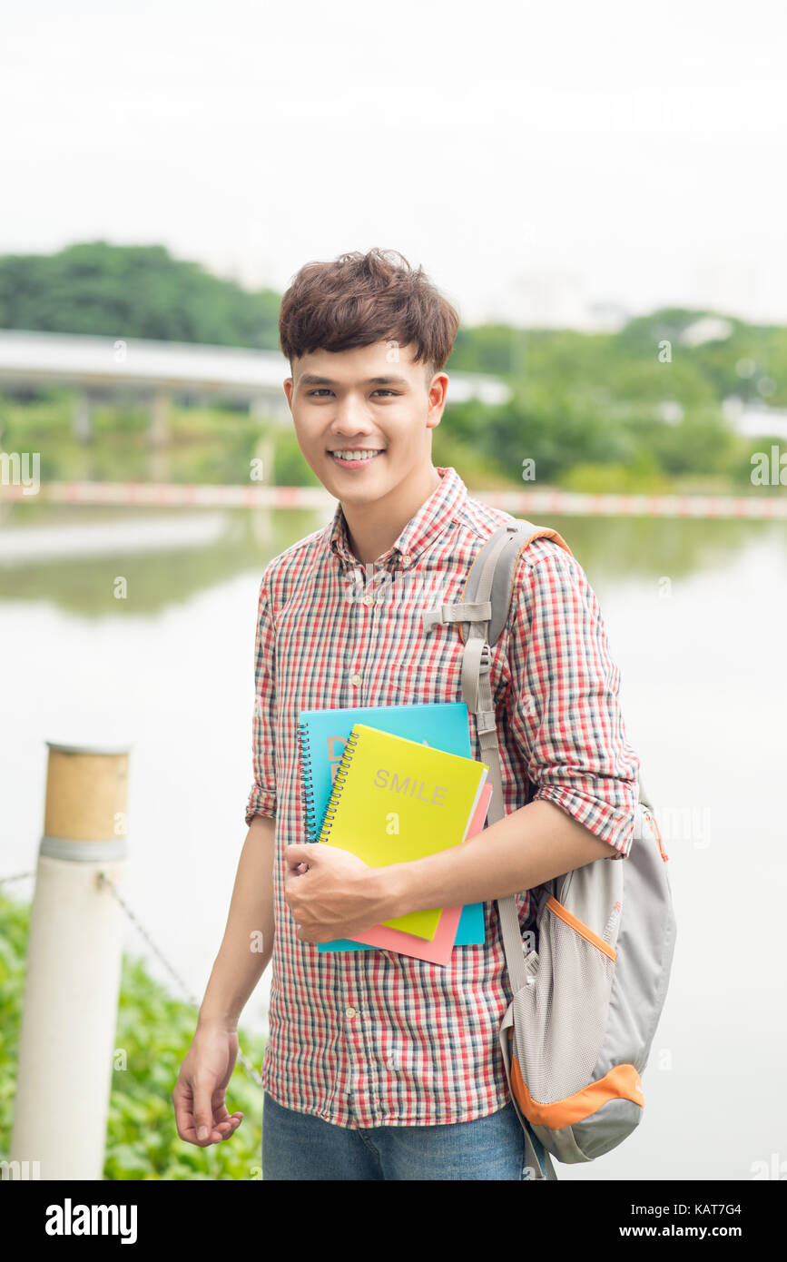 College asian male student holding book on the park Stock Photo