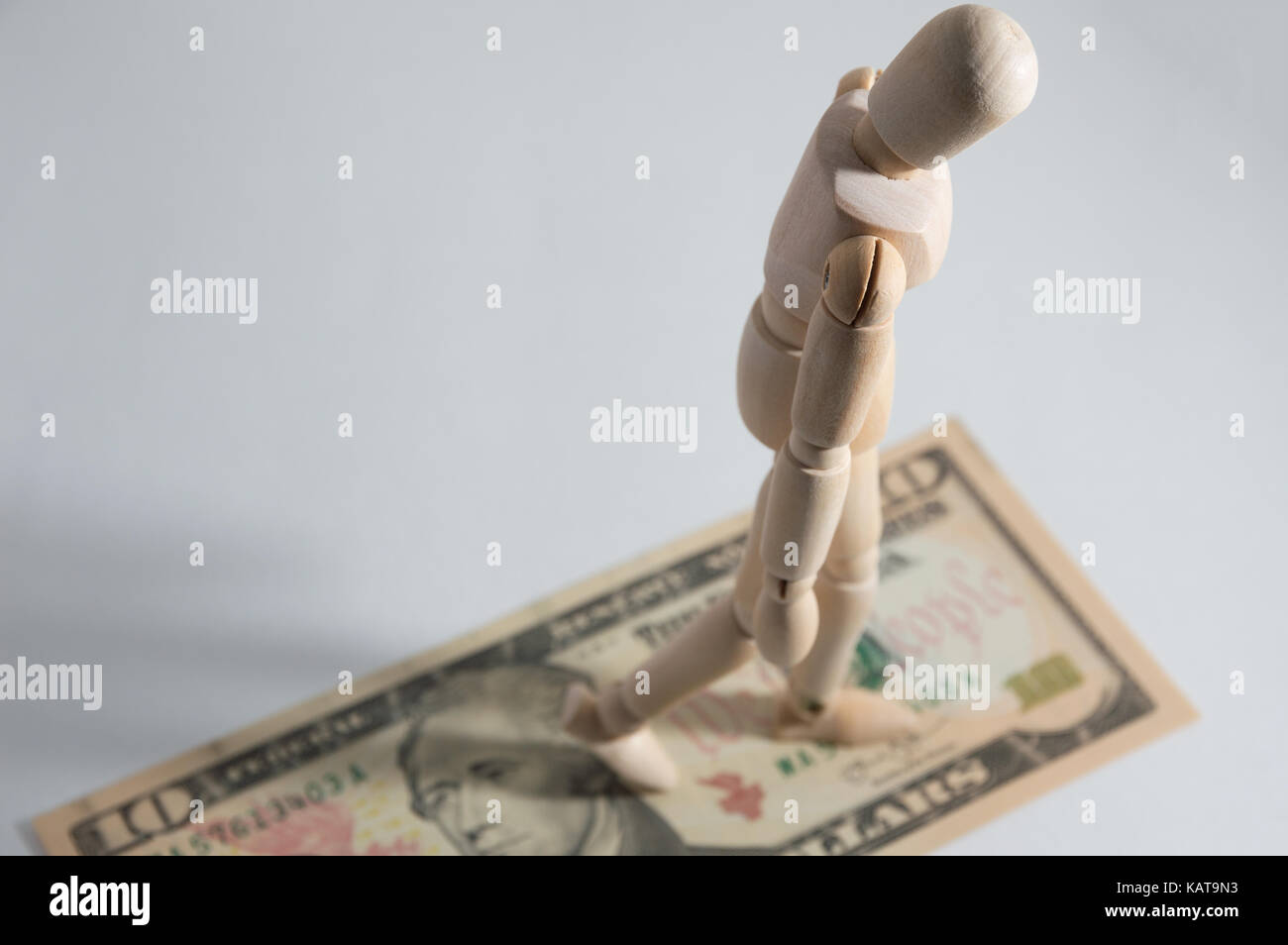 Wooden jointed doll on dollar Stock Photo