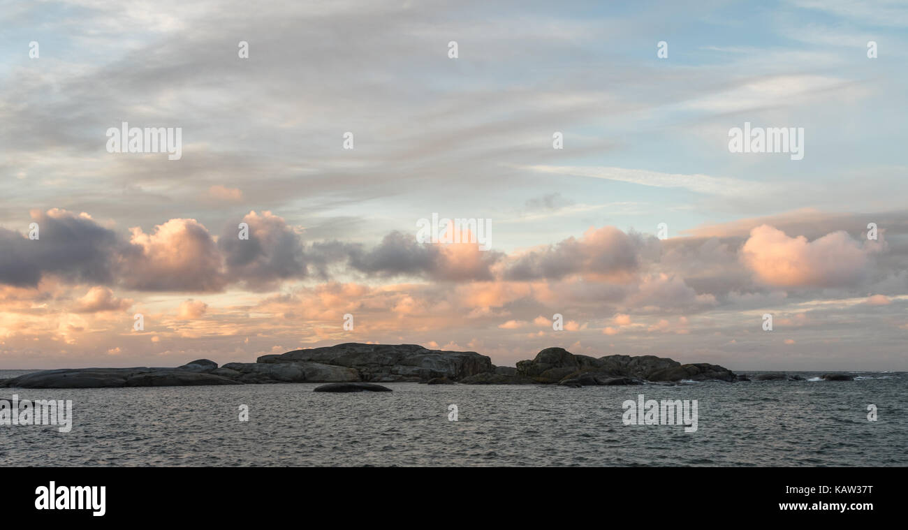 Sunrise with pink sky and clouds over the ocean and archipelago of Faerder national park, Verdens Ende, Vestfold, Norway Stock Photo
