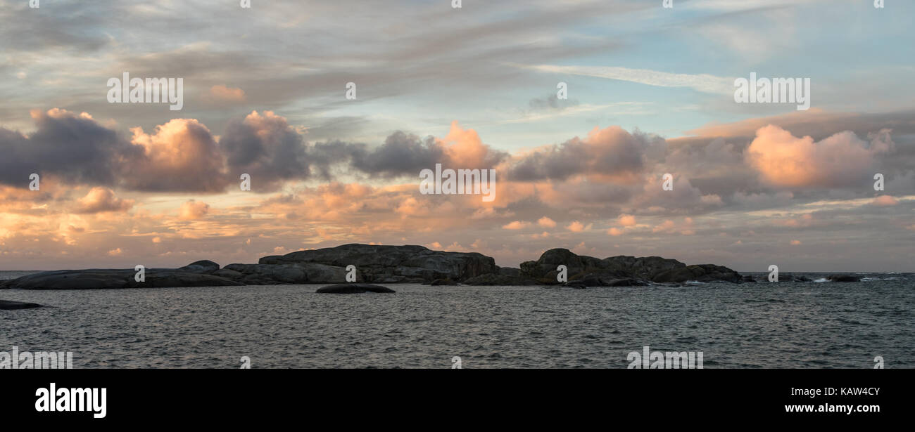 Sunrise with pink sky and clouds over the ocean and archipelago of Faerder national park, Verdens Ende, Vestfold, Norway Stock Photo