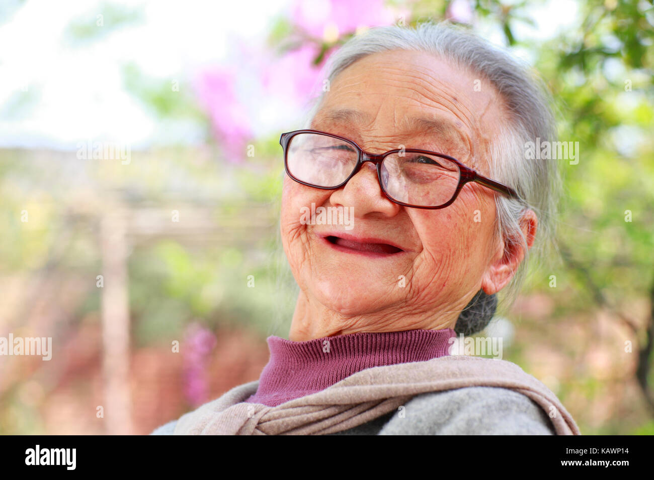 One happy Senior Chinese woman reading book in the yard Stock Photo