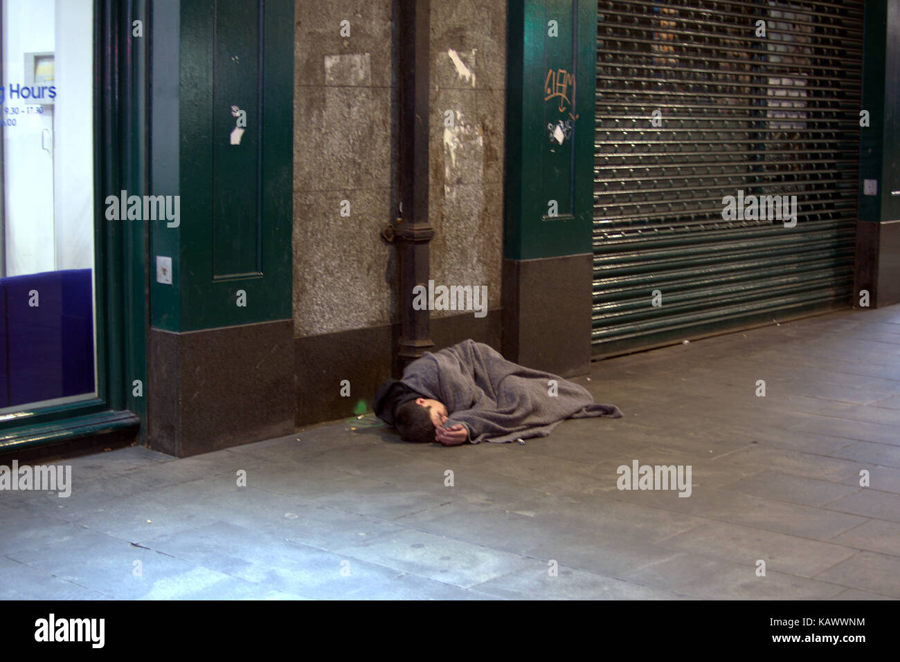 Hielanman's Umbrella highlanders umbrella Glasgow young homeless boy looks dead as he sleeps on ground unconscious as Stock Photo