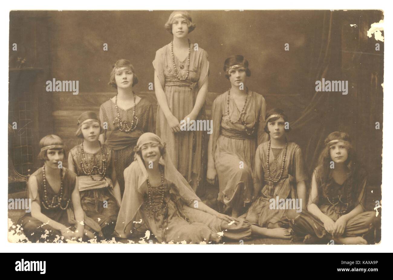 1920s postcard of girls posing, possibly in dance costumes, with fashionable bobbed flapper style hair cuts and headbands, long dresses, dated 1921 on reverse, U.K. Stock Photo